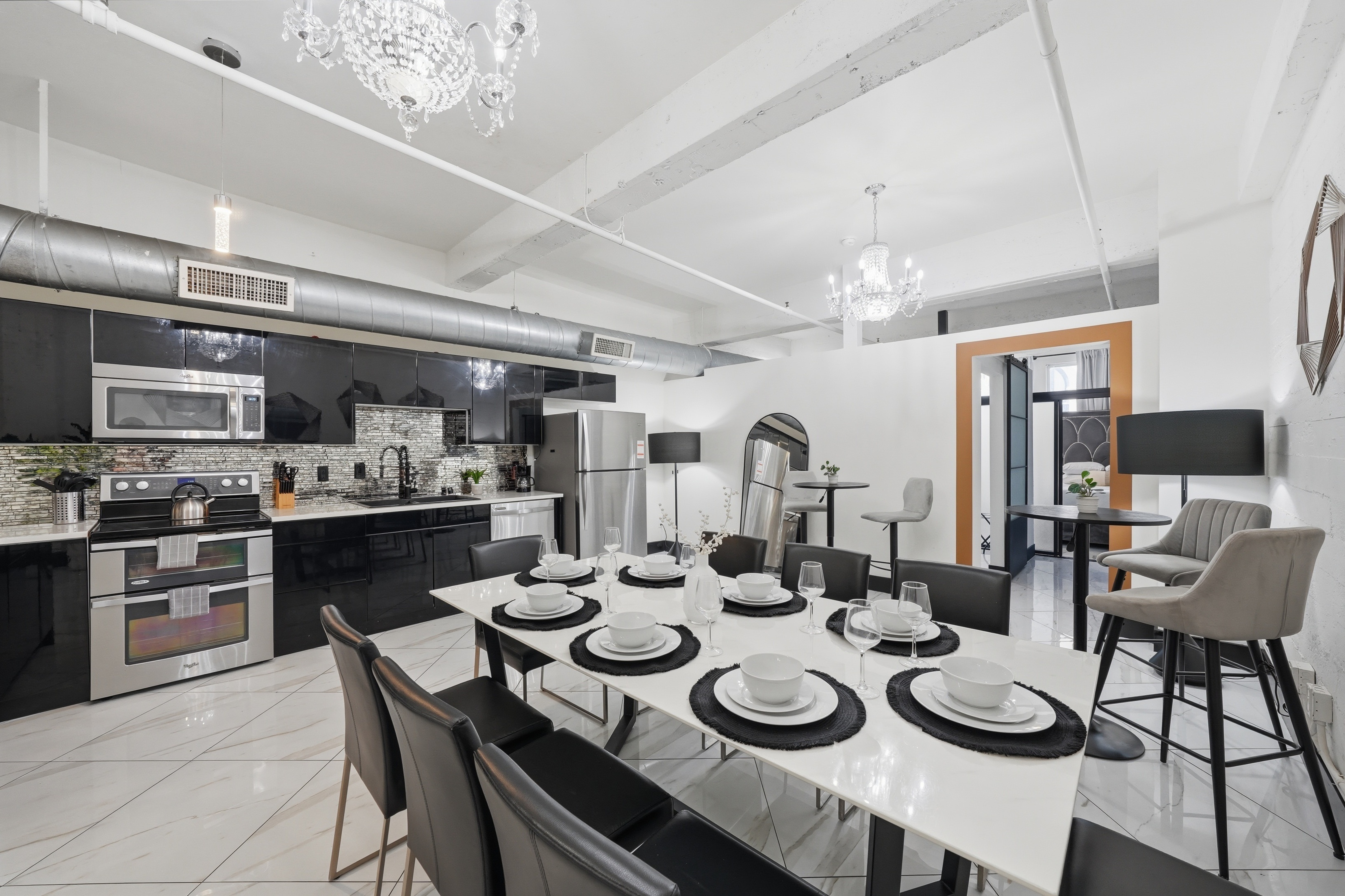 Unit 301 Champagne — black and white kitchen with crystal chandeliers and marble dining table